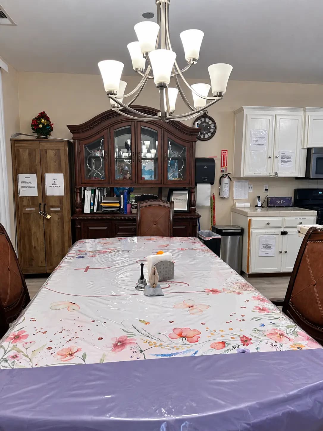 Laurite dining table beneath a chandelier beside the kitchen