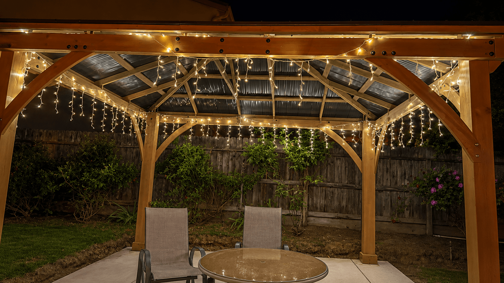 Covered patio at Joy in Caring with string lights and outdoor seating in the backyard