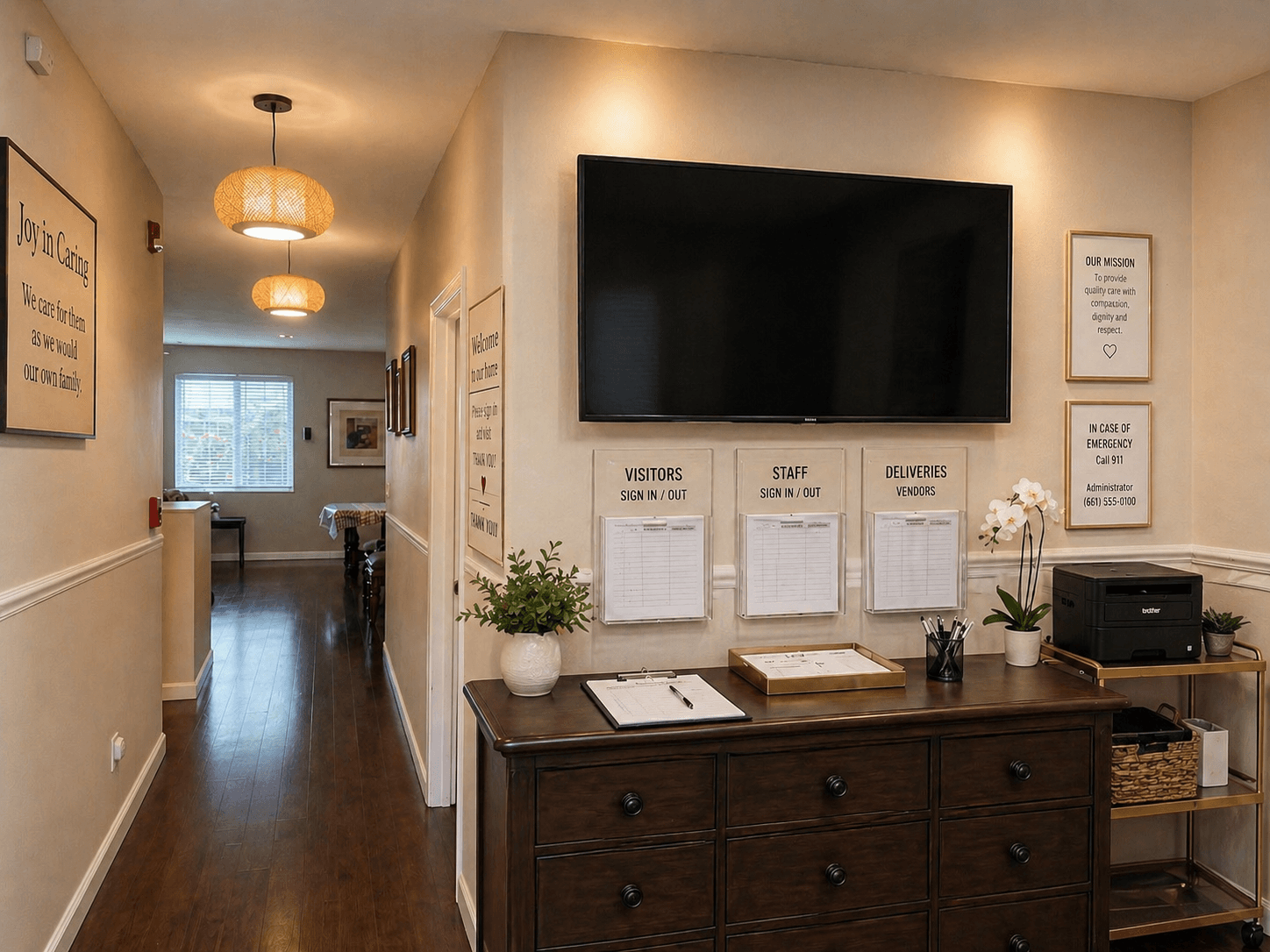 Entry hallway at Joy in Caring with a visitor/staff sign-in station and welcome message