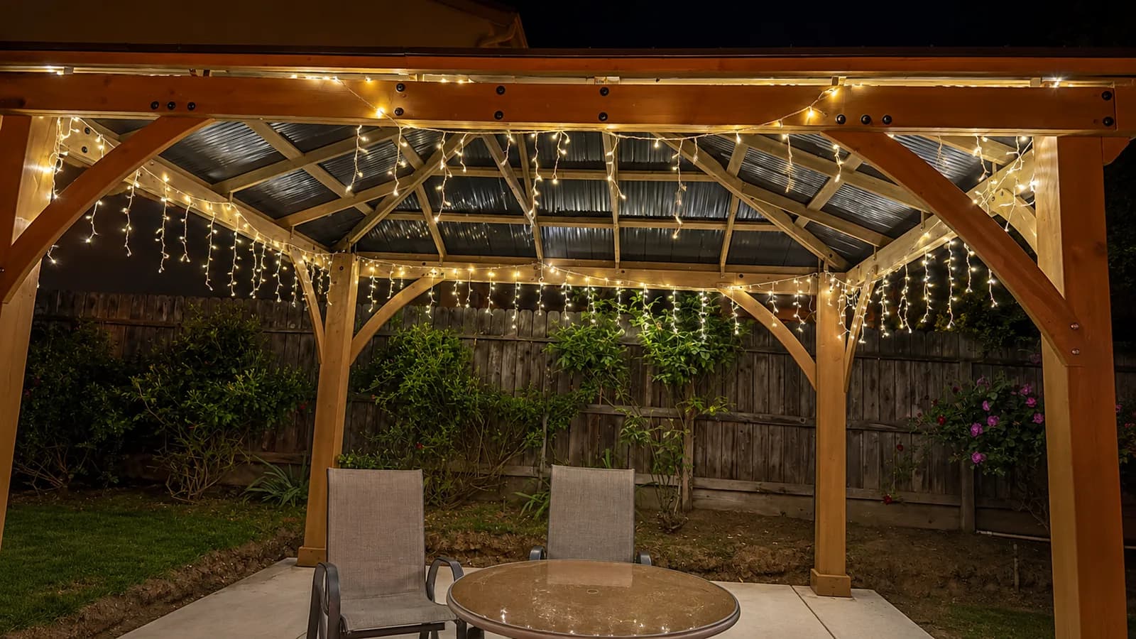 Covered patio at Joy in Caring I with string lights and outdoor seating in the backyard