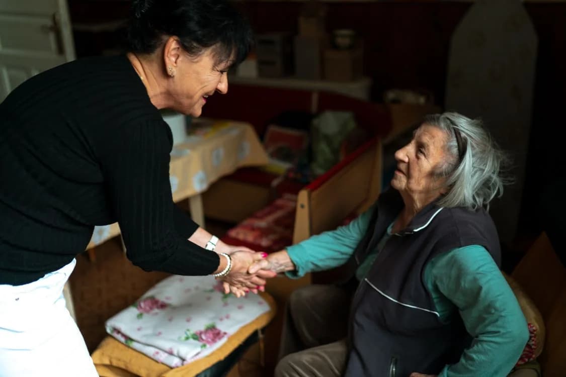Illustrative stock photo: A caregiver greeting an older woman